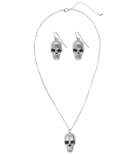 Schmuckset mit silberner Totenkopf Kette und Ohrringen vor dunklem Hintergrund