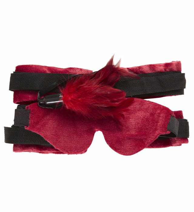 Bondage Set mit weichen Bändern, Augenbinde und Federn auf dunklem Hintergrund