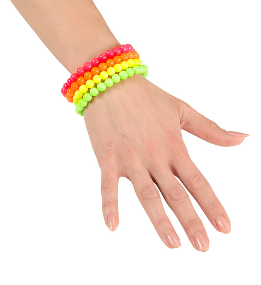 Ein Frauenhands mit vier neonfarbenen Kugel-Armbändern in Rot, Orange, Gelb und Grün.