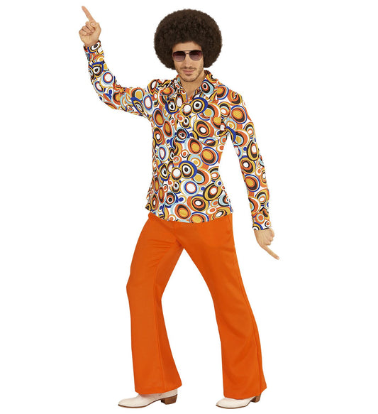 Man in 70s afro wig and sunglasses wearing a colorful bubble-print disco shirt and flared orange pants.