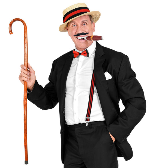 Man in black suit with straw hat, bow tie, suspenders, mustache, cigar, and cane.