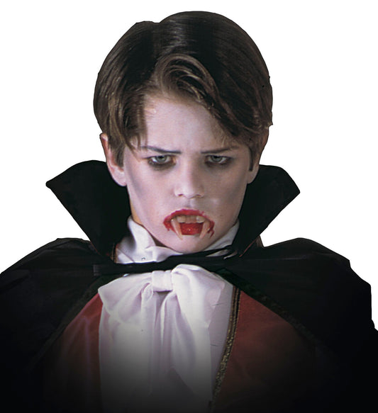 A boy in vampire costume with black cape, white shirt, and fake blood fangs.