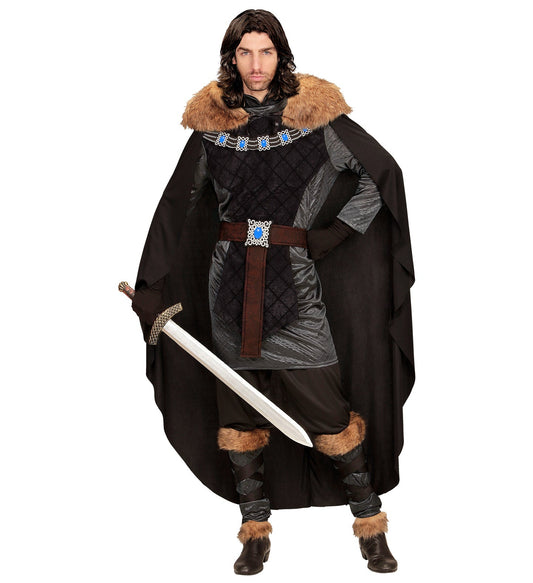 Man in medieval prince costume with tunic, fur-trimmed cape, belt, leggings, and sword.