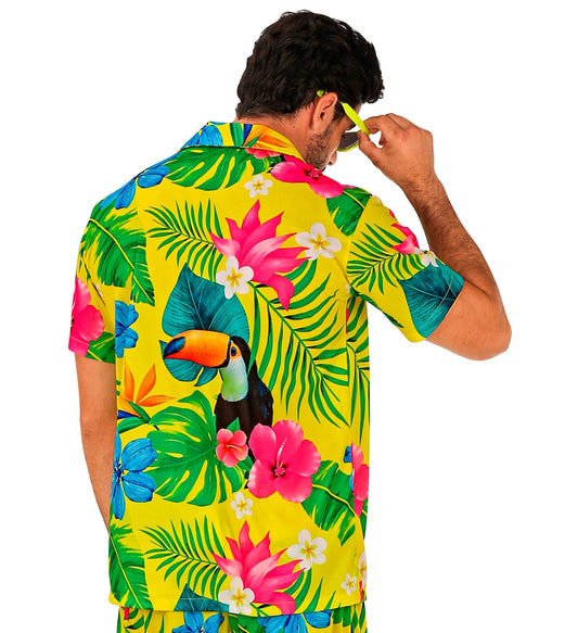 Rear view of a man wearing a yellow tropical print shirt with pelican, featuring vibrant flowers and leaves.