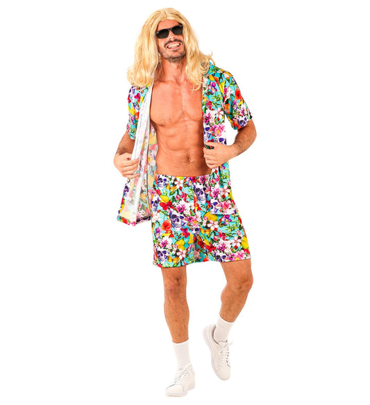 Man in open floral Hawaiian shirt with skull prints and matching shorts, posing casually.