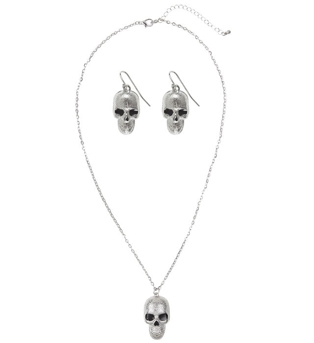 Schmuckset mit silberner Totenkopf Kette und Ohrringen vor dunklem Hintergrund