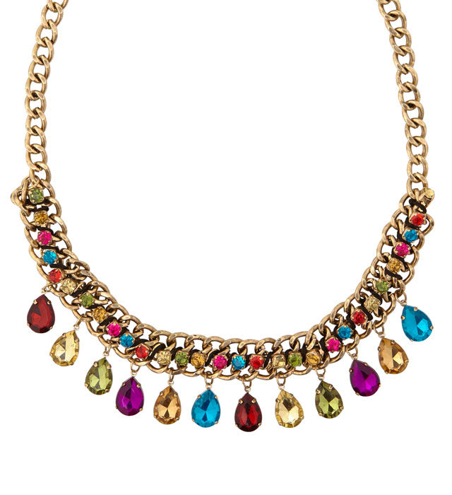 Goldene Kette mit bunten Schmucksteinen auf weißem Hintergrund