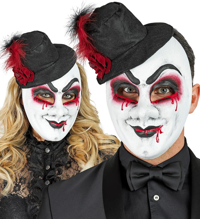 Blutige Commedia dell'Arte Maske mit Hut auf schwarzem Hintergrund
