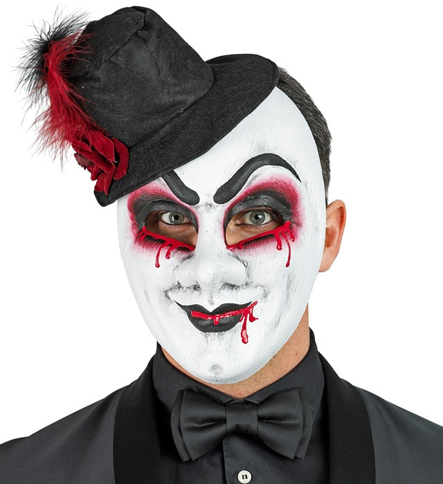 Blutige Commedia dell'Arte Maske mit Hut auf schwarzem Hintergrund