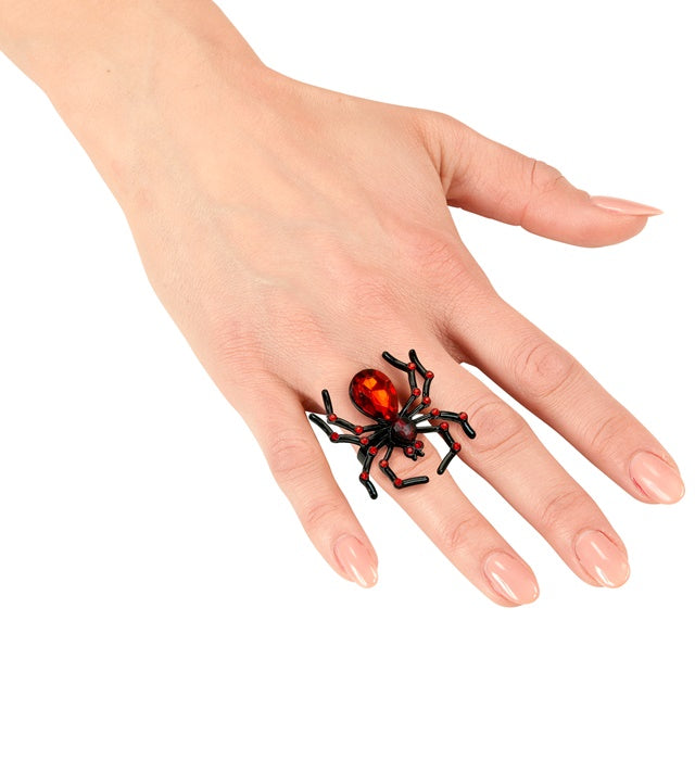 Spinnenring mit rotem Strass-Edelstein auf schwarzem Hintergrund