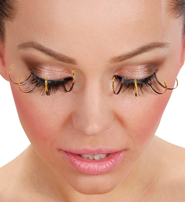 Schwarze lange Wimpern mit goldfarbenem Rand und Klebstofftube