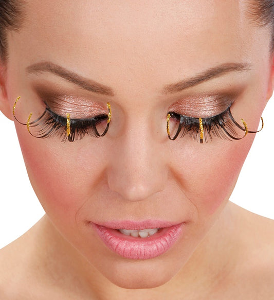Schwarze lange Wimpern mit goldfarbenem Rand und Klebstofftube