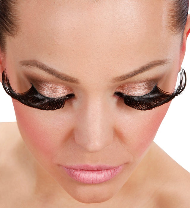 Schwarze superlange künstliche Wimpern mit Klebstofftube auf weissem Hintergrund