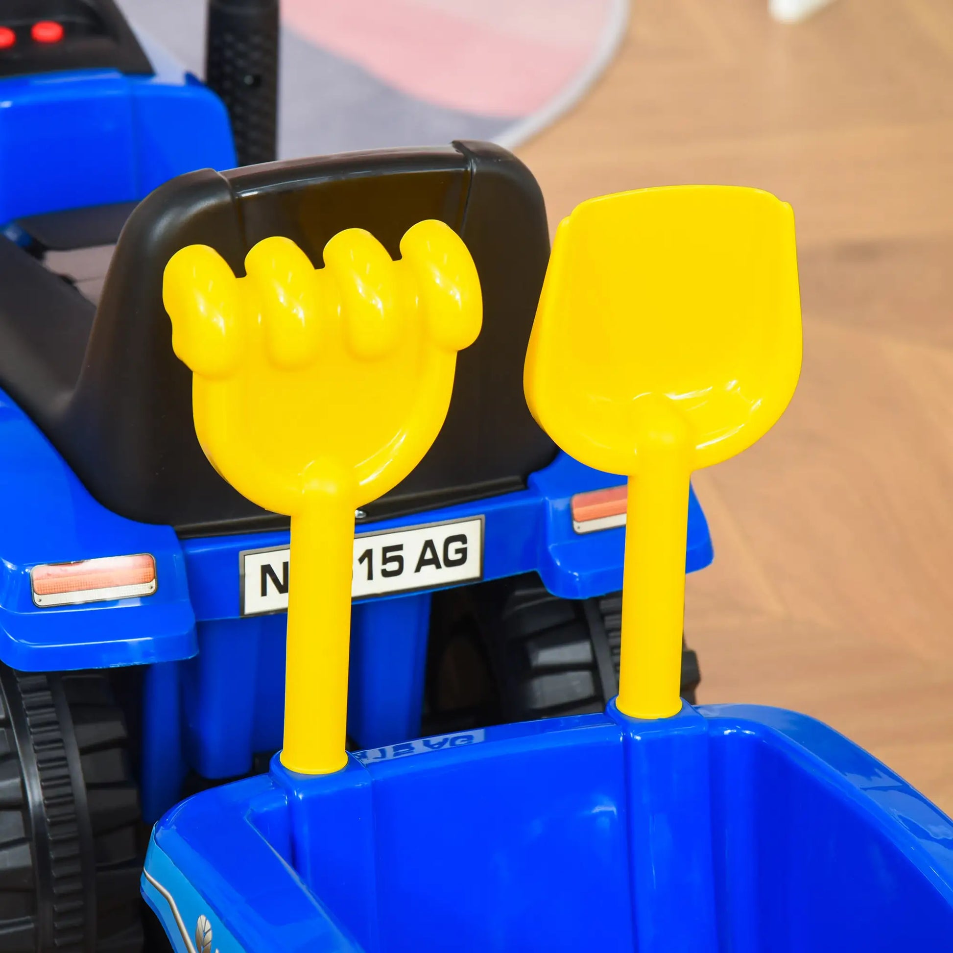 Blauer Rutsch-Traktor aus Kunststoff und Metall mit Anhänger, geeignet für Kinder von 1-3 Jahren.