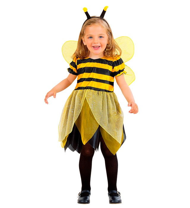 Kind trägt Bienen-Kostüm mit gestreiftem Kleid, Flügeln und Antennen