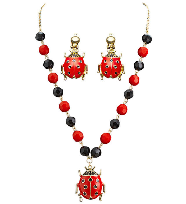 Schmuckset mit Marienkäfer-Kette und passenden Ohrringen auf weißem Hintergrund