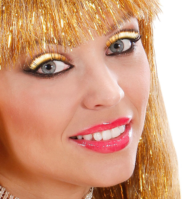 Goldmetallische künstliche Wimpern mit Kleber in Glasflasche auf weißem Hintergrund