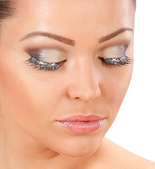 Silberne künstliche Wimpern mit Kleber in Glasflasche in einer Box