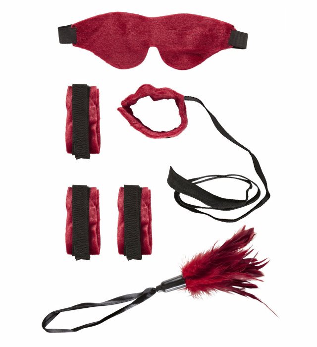 Bondage Set mit weichen Bändern, Augenbinde und Federn auf dunklem Hintergrund