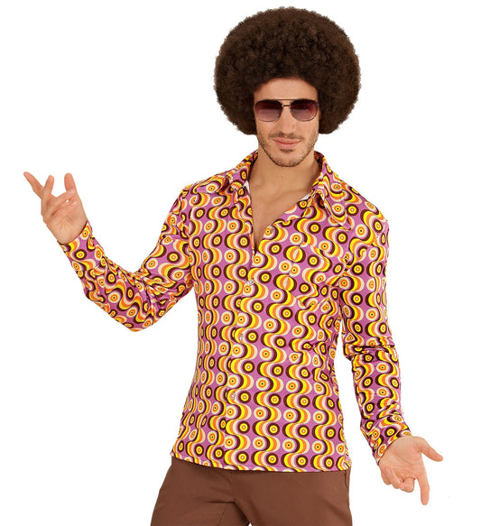 Man in afro wig and sunglasses wearing a colorful 70s disco shirt with circular patterns.