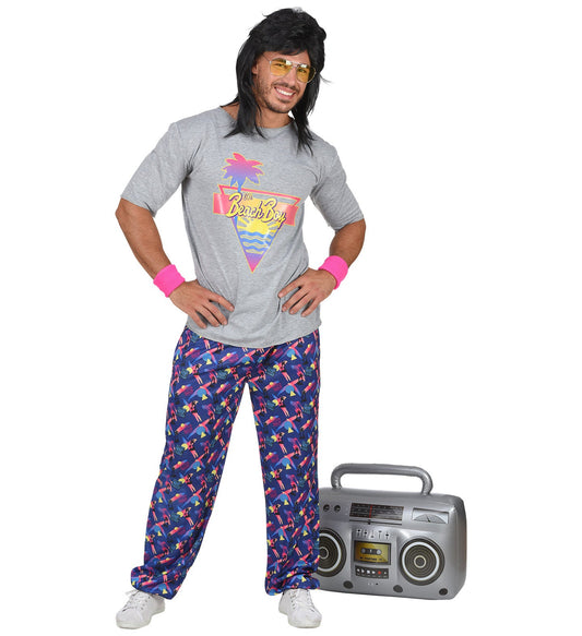 Man in 80s beach boy costume with retro palm print shirt, patterned pants, and boombox.