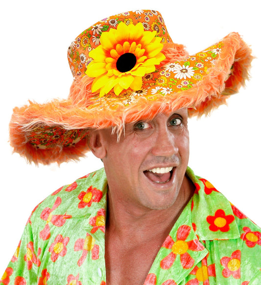 Orange hippie hat with plush trim and large sunflower, worn by smiling man in floral shirt.