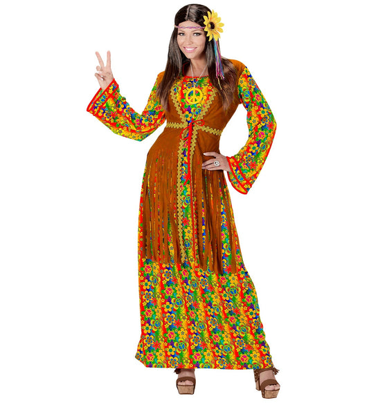 Woman in colorful hippie dress with fringed vest and peace necklace, making peace sign.