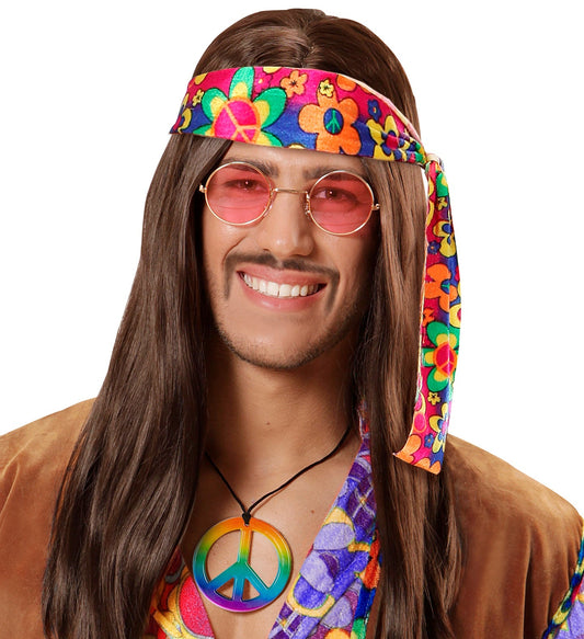 Man wearing a colorful floral headband, pink sunglasses, peace necklace, and patterned shirt.