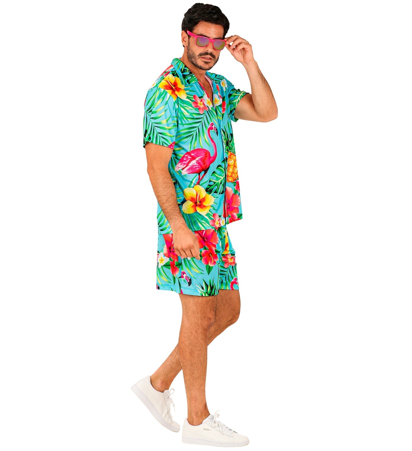 Man in turquoise Hawaiian shirt and shorts with flamingos and pineapples.