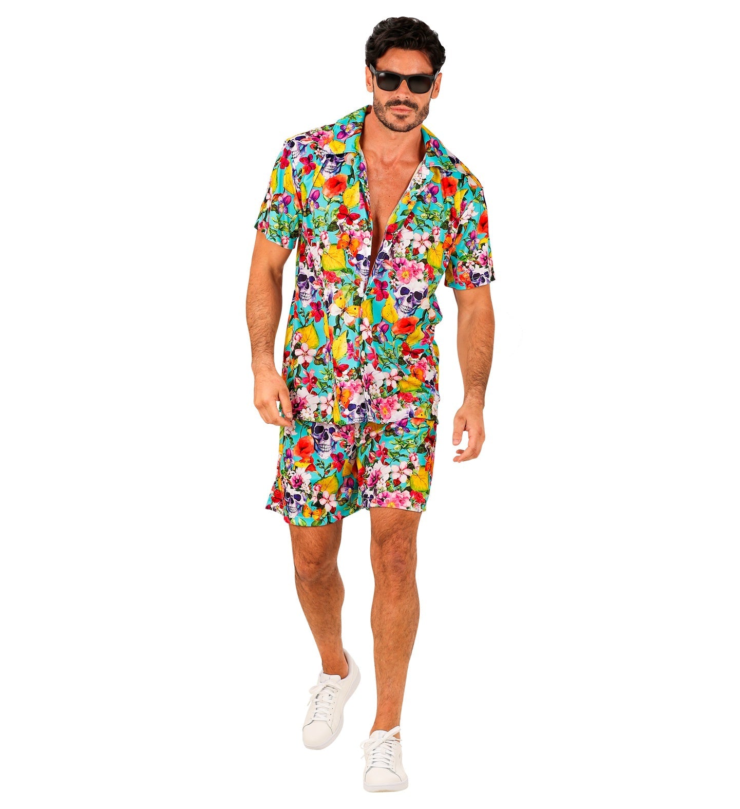 Man in colorful Hawaiian shirt and shorts with skull print, wearing sunglasses and white sneakers.