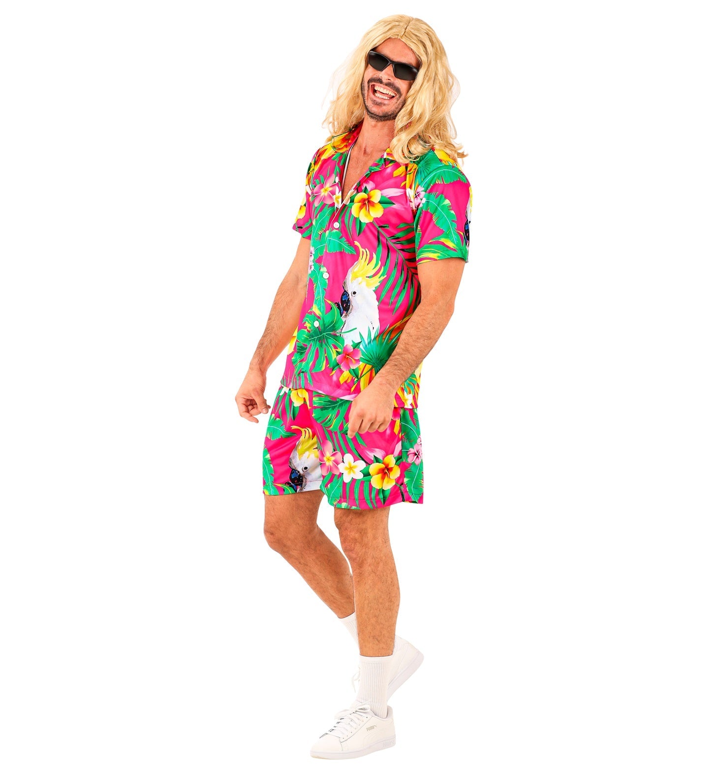 Man in pink tropical Hawaiian shirt and shorts set with long blonde wig, standing casually.