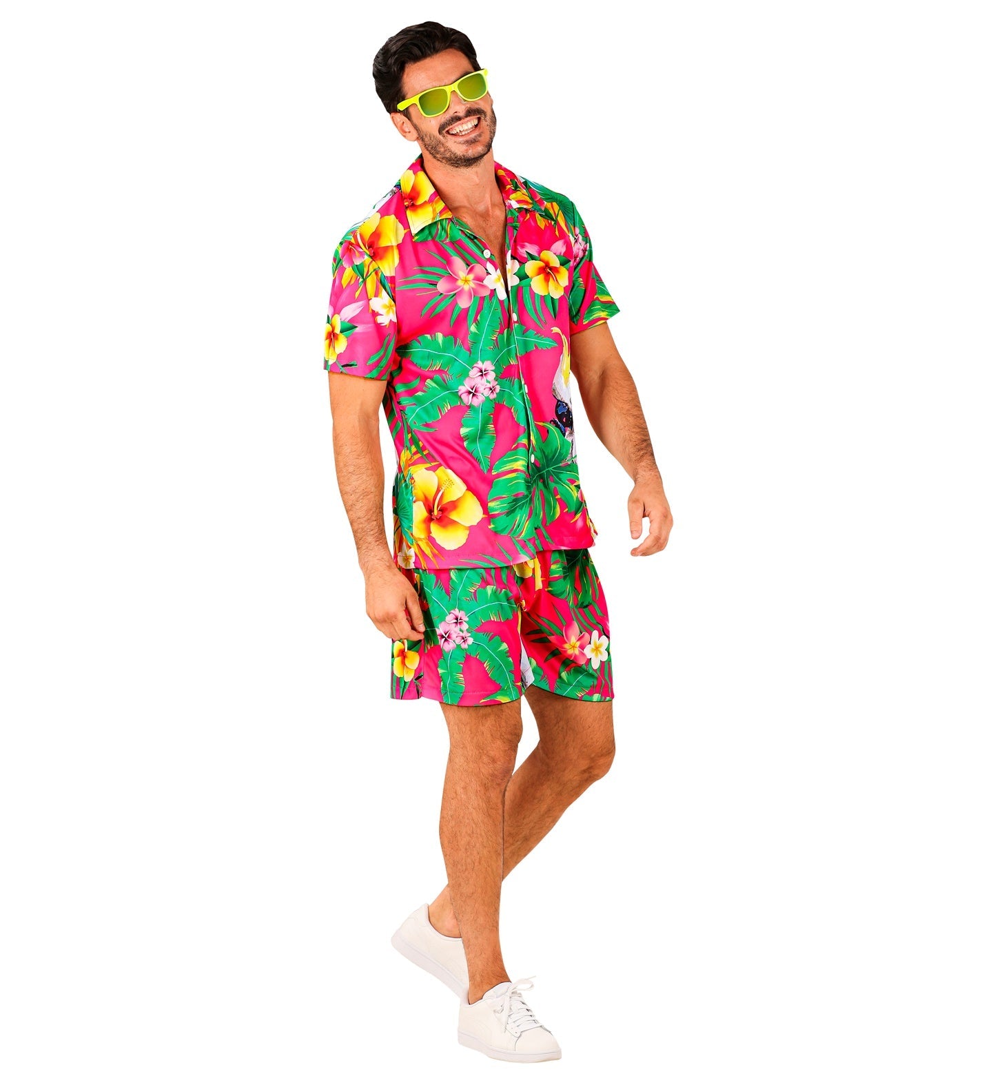 Man in pink tropical Hawaiian shirt and shorts set with hibiscus print, wearing sunglasses and white sneakers.