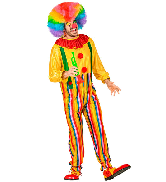 Man in colorful Widmann circus clown costume with rainbow wig, ruffles, suspenders, and green prop.